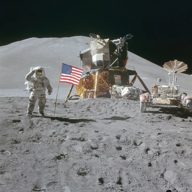 The Salute at Hadley Rille. Jim Irwin salutes the flag beside the first car ever driven on the Moon, the Lunar Roving Vehicle.