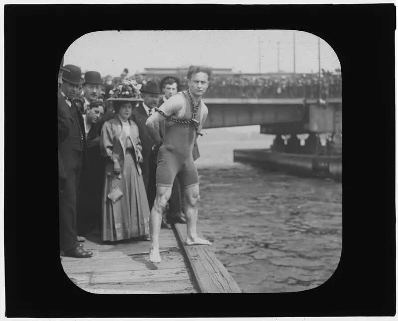 Houdini Leaps from Harvard Bridge, 1908. Shackled in handcuffs and chains, Houdini jumped into Boston's Charles River before a crowd of thousands and freed himself underwater.